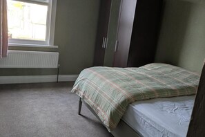 A bedroom with a bed, a radiator, and a window. - Central Stratford Gem (London)