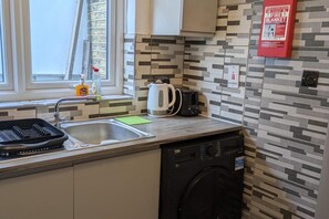 A kitchen with a dishwasher, a kettle, and a toaster on the counter. - Central Stratford Gem (London)