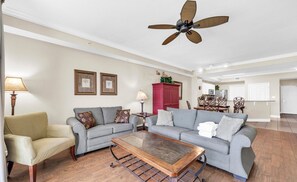 A living room with two sofas, a coffee table, and a ceiling fan. - Tidewater 1605- Sunset Dreams (Panama City Beach)