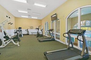A gym with treadmills, stationary bikes, and weight machines. - Celadon 408 (Panama City Beach)