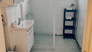 Un baño con lavamanos blanco, inodoro y cabina de ducha de vidrio.