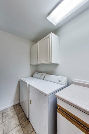 A laundry room with a washer, dryer, and cabinets. - Lake Front Getaway on Channel Lake (Antioch)