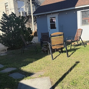 A small house with a blue exterior, a front door, and a window. There are two wooden chairs and a bench outside. - THE ARTFUL TIDE - Unit B/Beautiful 2 BR/1BA Mansion Suite (Atlantic City)