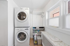 A laundry room with two stacked washing machines, a drying rack, and a radiator. - THE ARTFUL TIDE - Unit B/Beautiful 2 BR/1BA Mansion Suite (Atlantic City)