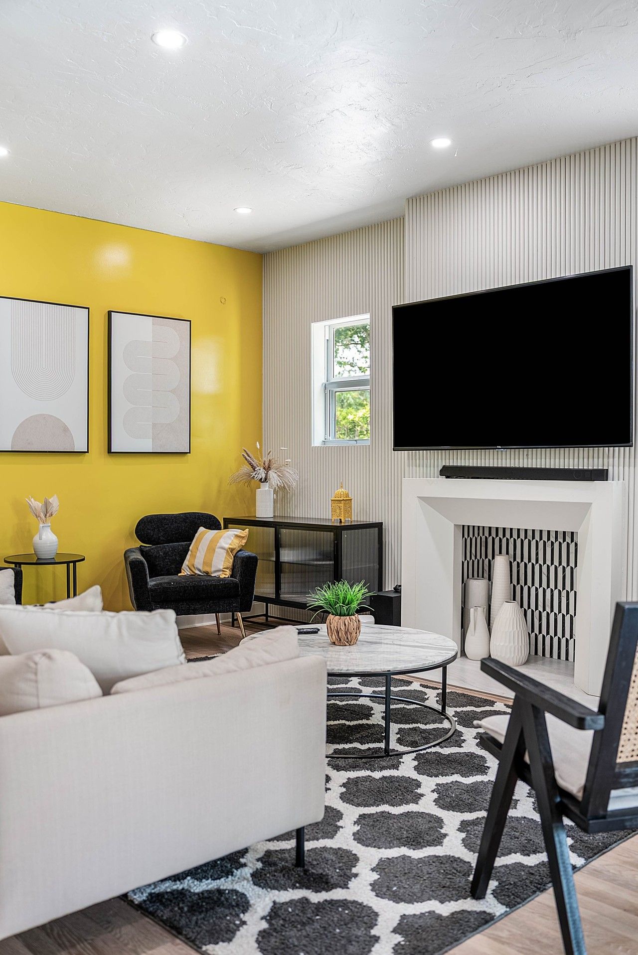 Een moderne woonkamer met een bank, fauteuil en een open haard.