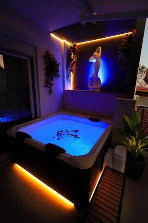 A spa area with a heated pool, a statue, and potted plants.