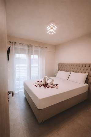 A hotel room with a large bed, a tufted headboard, and a decorative swan made of rose petals on the bed. - Luxury Apartment and wirlpool over athen/Kesariani (Kesariani)