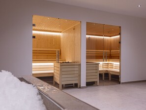 A sauna with wooden benches and a glass partition. - Holiday Apartment With 3 Bedrooms (Mittersill)