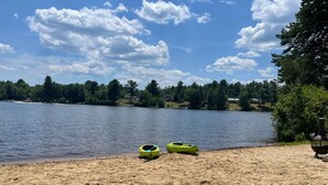 Ein Sandstrand mit Kajaks und einem Grill.