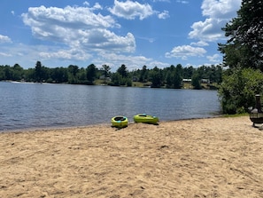 Une plage de sable avec des kayaks et un barbecue.