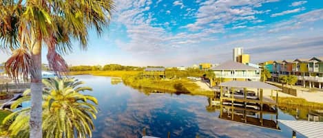 A waterfront property with a dock, a body of water, and buildings in the background.