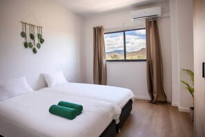 Une chambre d’hôtel dotée d’un grand lit, offrant une vue sur l’extérieur et équipée d’un système de climatisation.