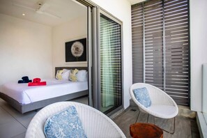 Een moderne slaapkamer met een bed, een stoel en uitzicht.