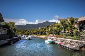 A marina with boats docked, a waterway, and buildings with tropical landscaping. - West Island CW9 · Sunrise Three Bed Apart in Marin (Grande Riviere Noire)