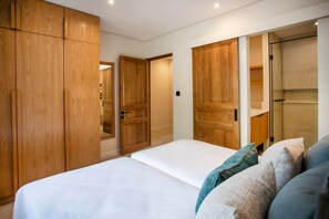 Un dormitorio con cama, armarios de madera y un espejo.