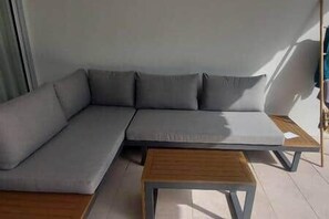 A modern living room with a sectional sofa, a wooden coffee table, and a view of the outdoors. - Townhouse with 3 suites and private pool (Tamarin)