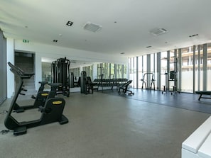 Academia com equipamentos de cardio, pesos livres e halteres.