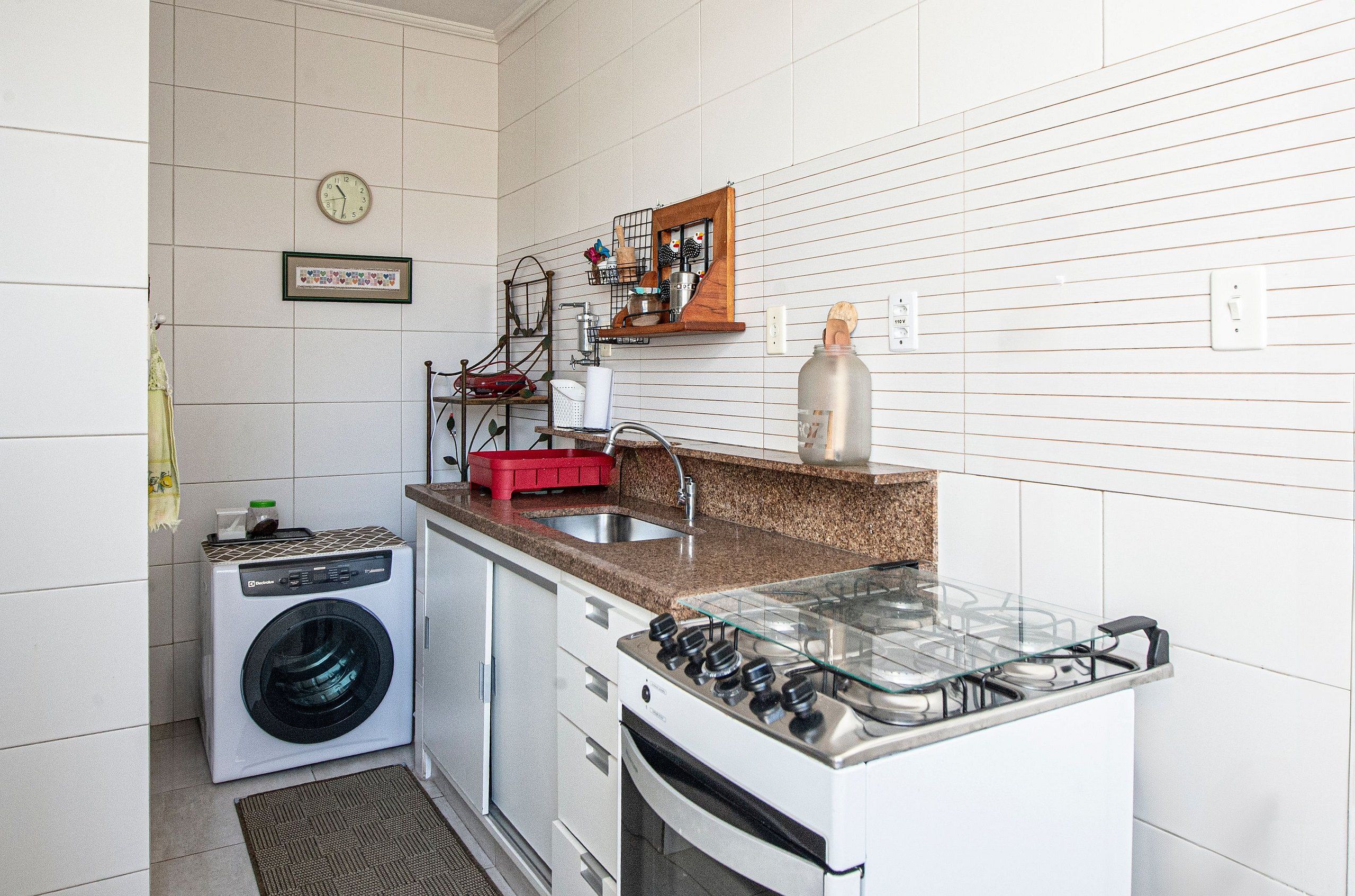 Una cocina compacta equipada con lavadora, cocina a gas y microondas.
