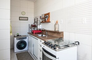 Una cocina compacta equipada con lavadora, cocina a gas y microondas.