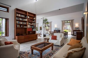 A spacious living room with a large bookshelf, a coffee table, and a sofa.