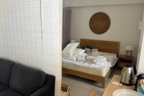 Ein Schlafzimmer mit einem Bett, einem Nachttisch, einer Lampe und einem runden Gegenstand an der Wand.