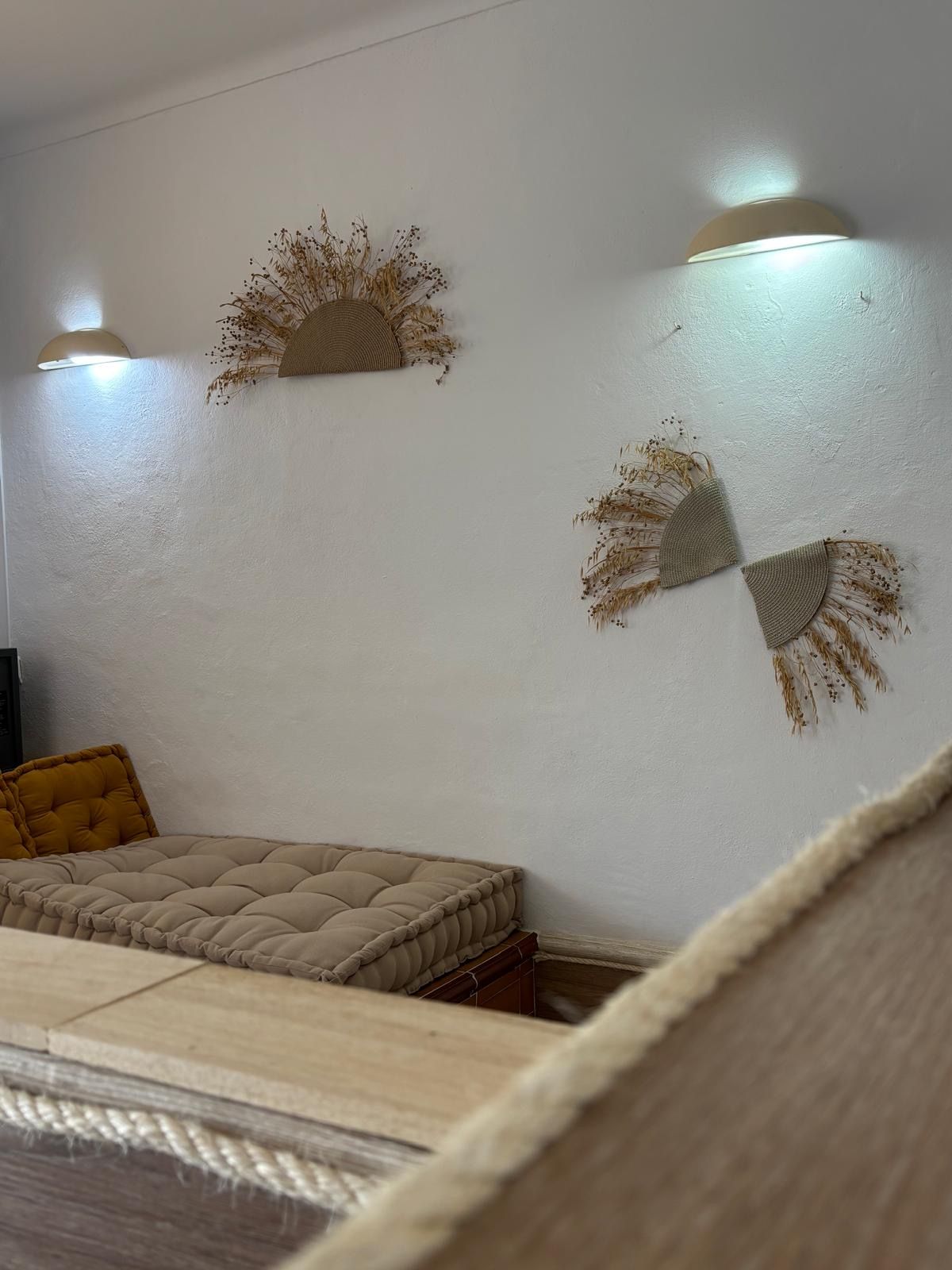 A room with a bed, two wall-mounted light fixtures, and decorative wall art.