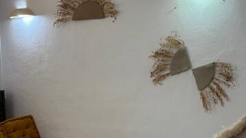 A room with a bed, two wall-mounted light fixtures, and decorative wall art.