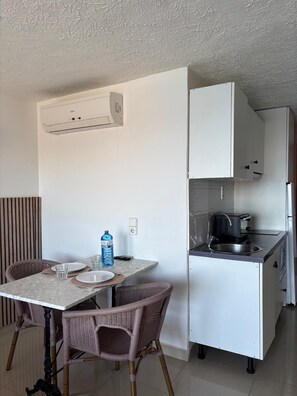 A compact kitchen with a built-in stove, a sink, and white cabinets.