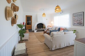 A living room with a fireplace, a sofa, a coffee table, and a dining table.