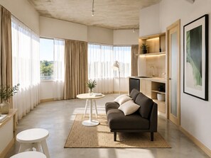 A modern living room with a sofa, a small round table, and a bookshelf. - Spacious 2-bed Darwin CBD Apartment Escape (Darwin)