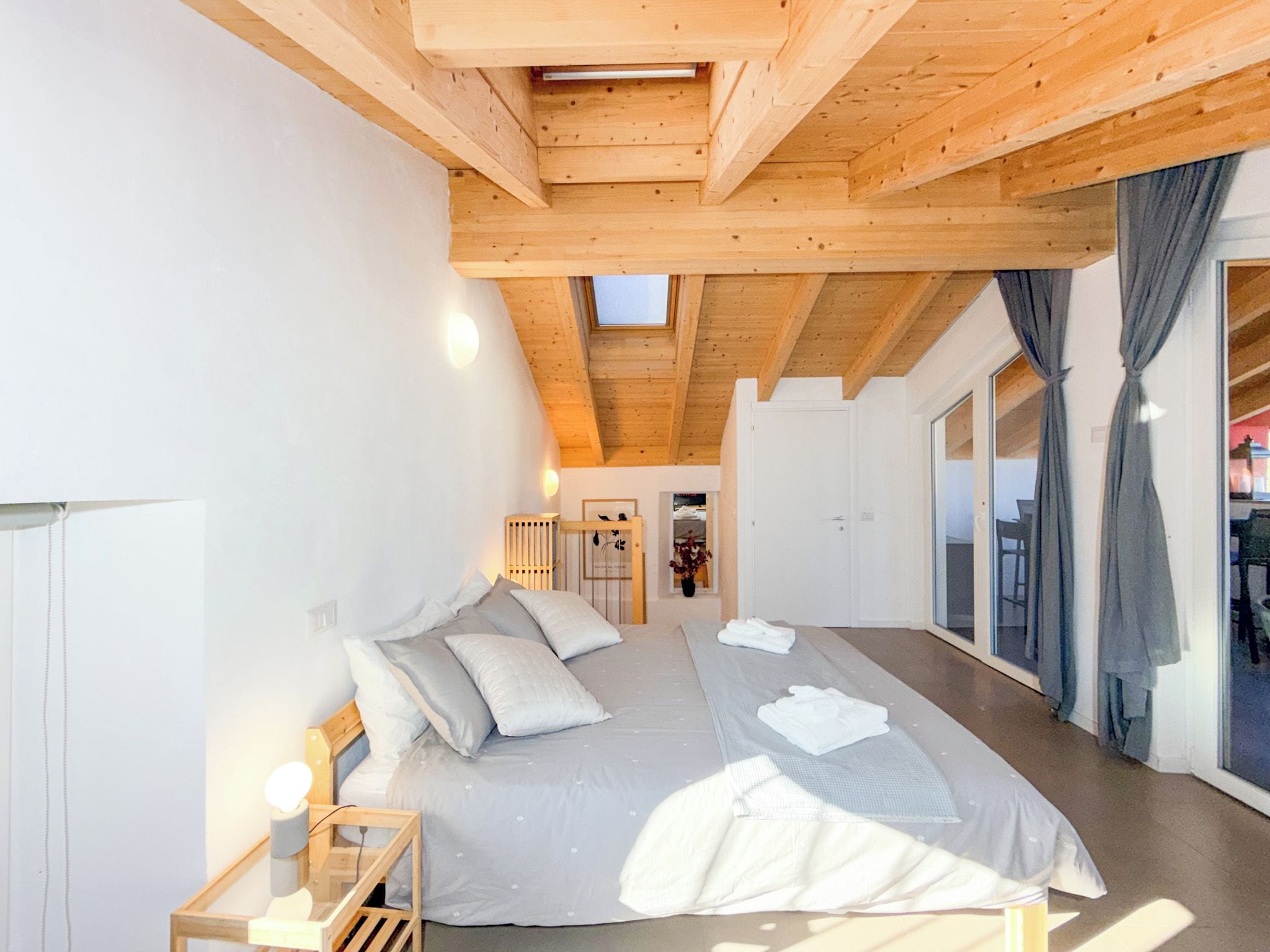 Ein geräumiges Schlafzimmer mit einem großen Bett, einem Oberlicht und Blick ins Freie.