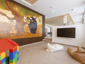 A modern interior with a mural, a flat-screen TV, and a play area with building blocks. - Penthouse With 5 Bedrooms (Mittersill)