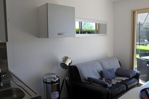 A modern living room with a sofa, a telescope, and a trash bin. - Holiday Home 'Gîte Bord De Mer' with Sea View, Private Terrace and Wi-Fi (Petit-Caux)