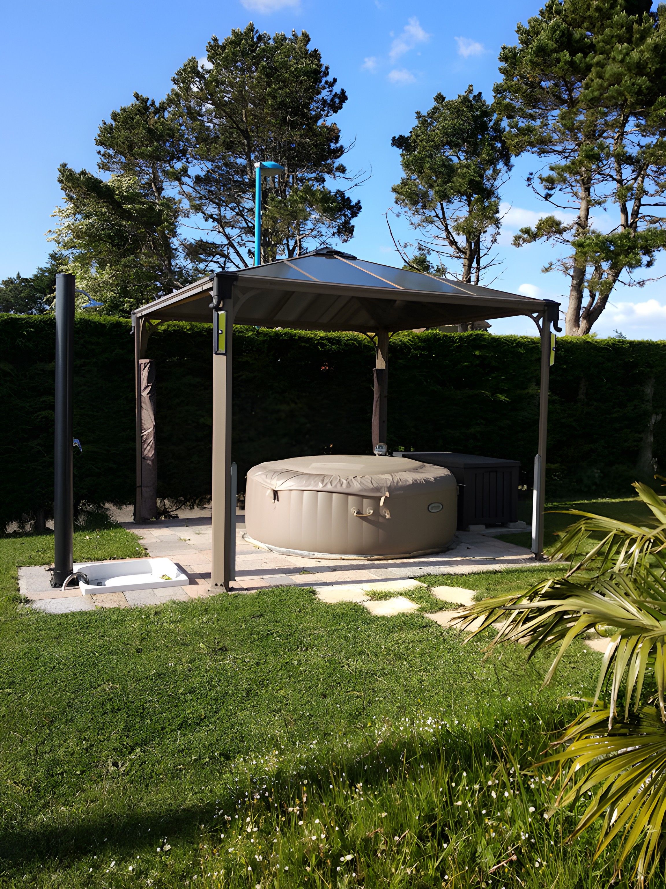 Een overdekt buitengebied met een jacuzzi, een pergola en een gazon.