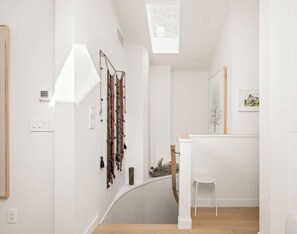 Ein modernes Interieur mit einer Wendeltreppe, einem Wandbild und einem gerahmten Bild.