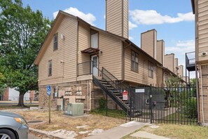 A two-story building with a ramp and a gated entrance.