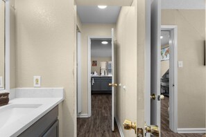 A hallway leading to a kitchen with cabinets and a countertop.