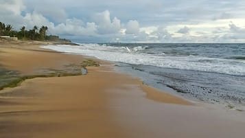 Una playa con arena y olas del océano.
