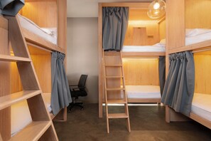 A bunk bed room with a ladder, wooden shelves, and a desk with a chair.