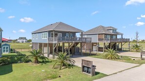 Une maison à deux étages avec un balcon et un espace extérieur couvert.
