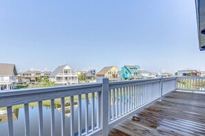 A wooden deck with a railing overlooking a residential area with houses. - Royal Beach Retreat | Sleeps 16 | 4Bd/2.5Bth (Bolivar Peninsula)