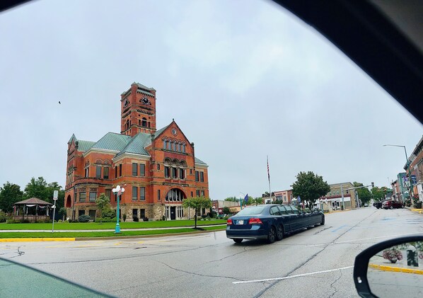 Un edificio histórico con una torre destacada y ventanas de arco.