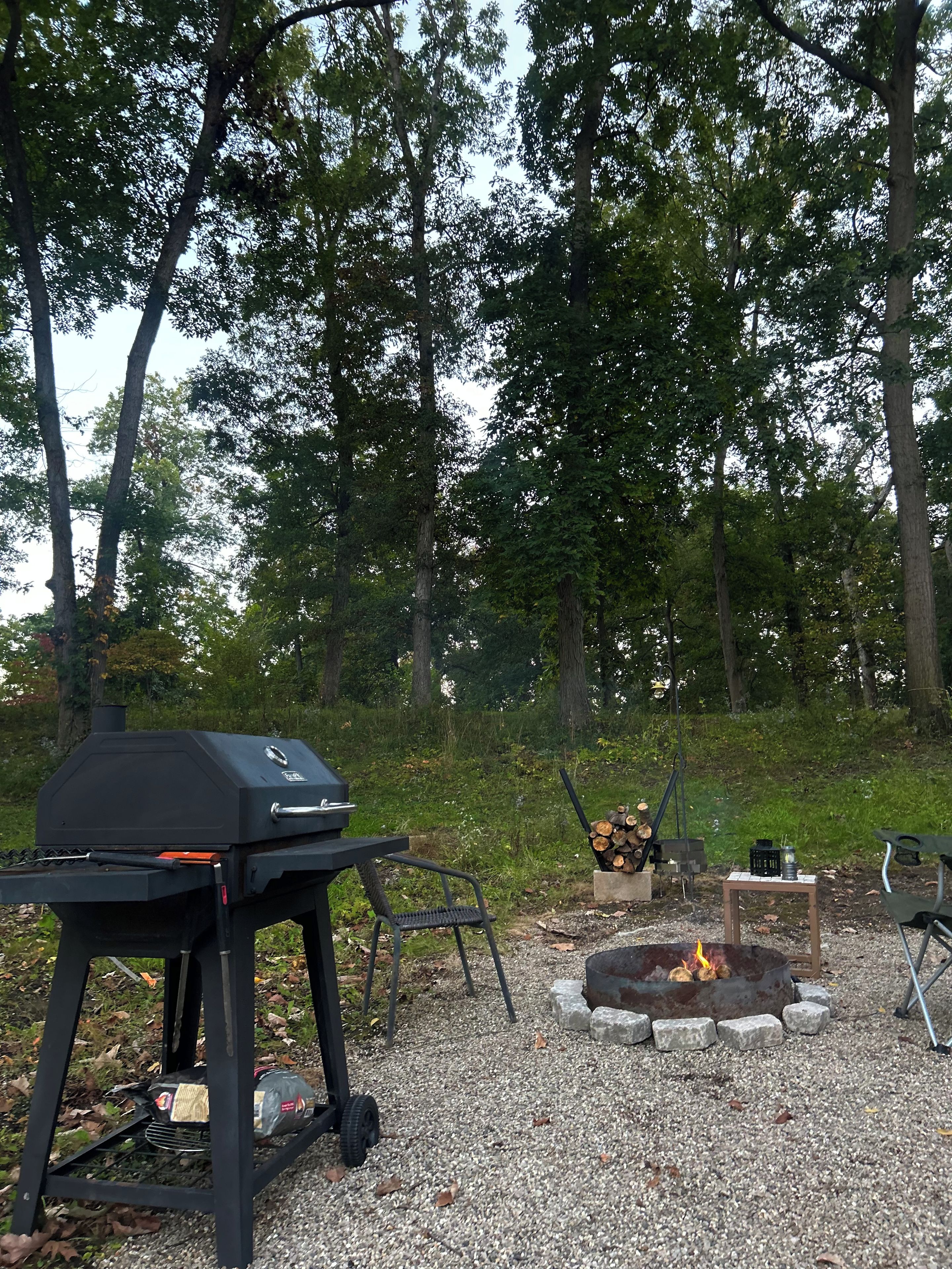 Un espace extérieur aménagé pour les barbecues, avec un gril, un foyer et des sièges.