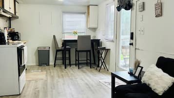 A compact living space with a kitchenette, dining area, and seating area.