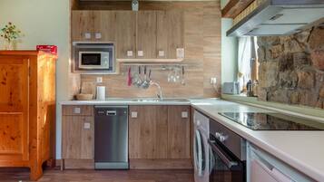 Una cocina moderna con armarios de madera, electrodomésticos de acero inoxidable y una pared de piedra.