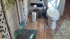 Un baño pequeño con inodoro, bidé y un cubo de basura.
