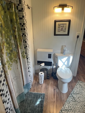 Un baño pequeño con inodoro, bidé y un cubo de basura.