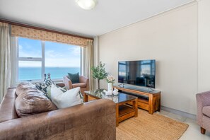 Una sala de estar con un sofá, una mesa de centro y una televisión.