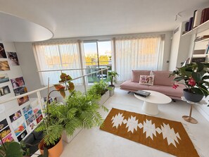 Un salon moderne avec un canapé, une table basse et des plantes en pot.