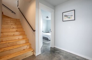 A wooden staircase leading to a bedroom with a bed and a framed picture on the wall. - Modern Mountain Retreat with Hot Tub & Boat Access Near Yellowstone, Island Park, Idaho (Island Park)